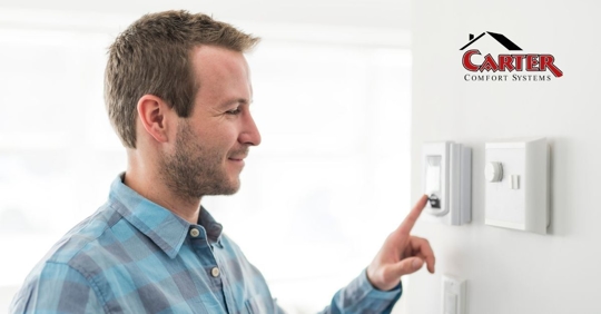 A homeowner adjusting his thermostat.