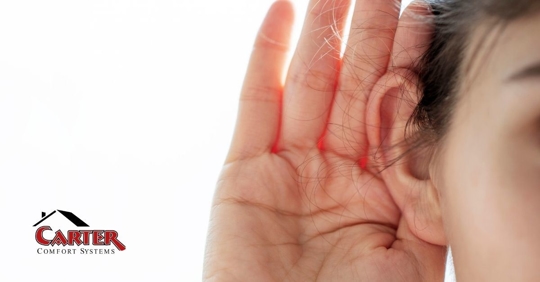 An adult woman listening to a noise.