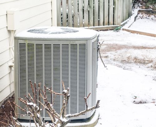 An outdoor HVAC unit in the snow