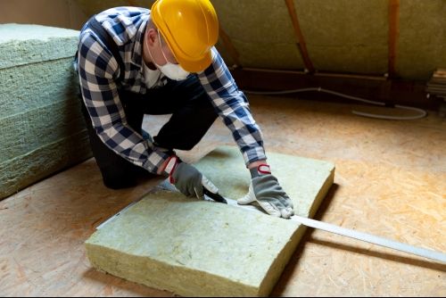 An HVAC technician installing insulation